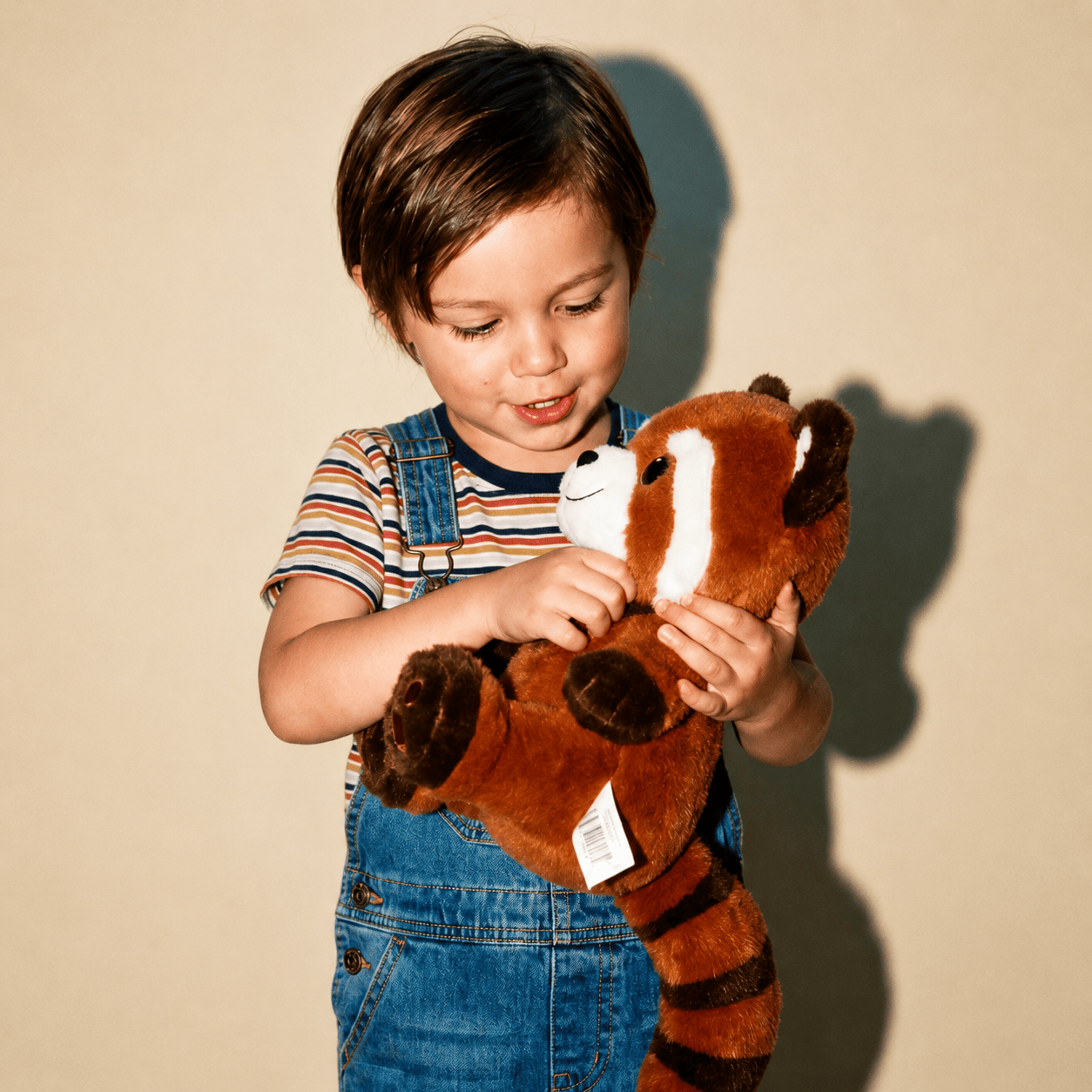 Child holding a Ruby the Red Panda v2 against a plain background