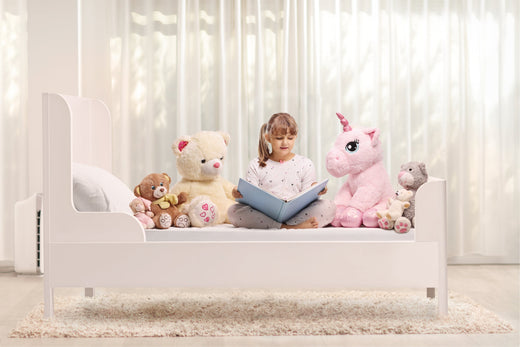 Girl reading books to her stuffed animal collection