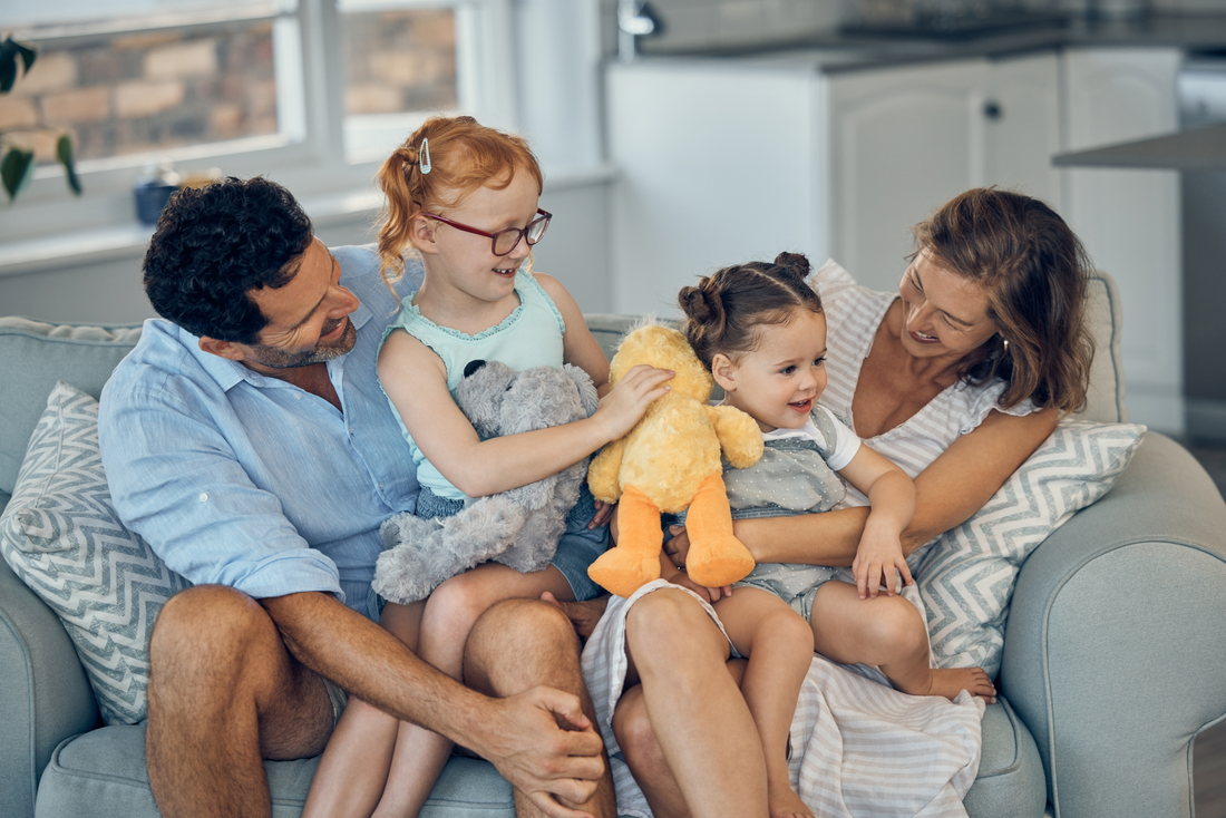 two young children and their parents playing with stuffed animals