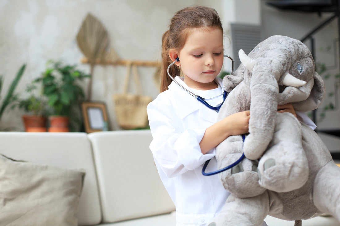 Child playing doctor with stuffed elephant