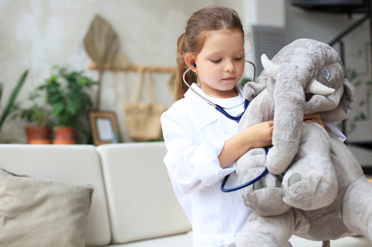 Child playing doctor with stuffed elephant