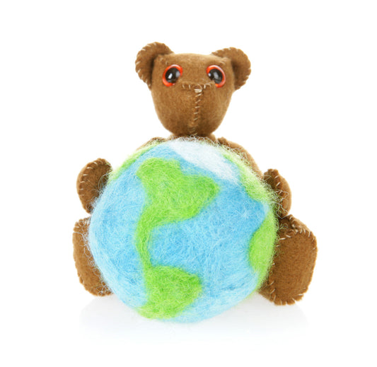 Hand stitched bear holding a knit globe