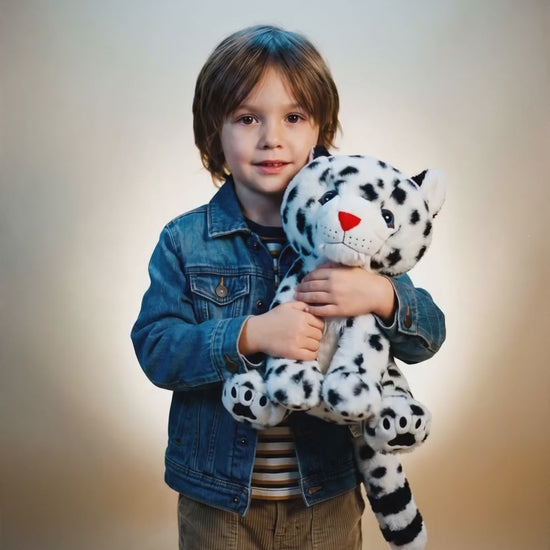 Child hugging Tashi the snow leopard plush stuffed animal