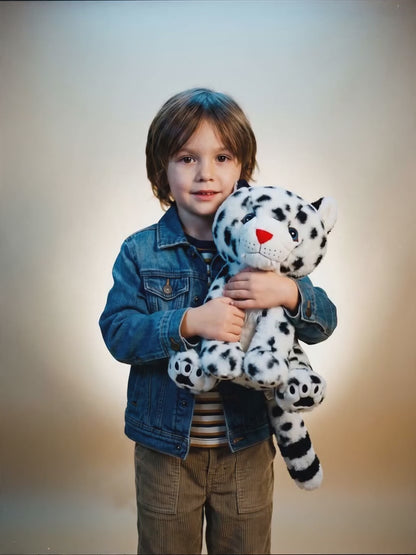 Child hugging Tashi the snow leopard plush stuffed animal